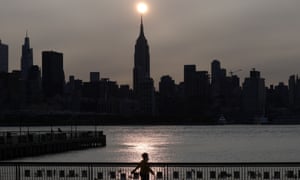 The sun rises behind the Empire State Building in New York City