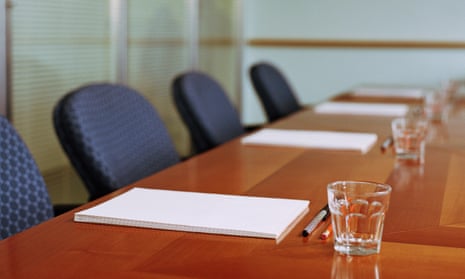 Notepads, pens and glasses on a boardroom table