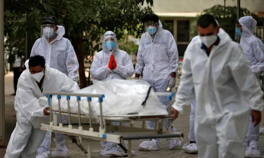Healthcare workers pull a stretcher carrying the body of a person who died from coronavirus in Ahmedabad, India.