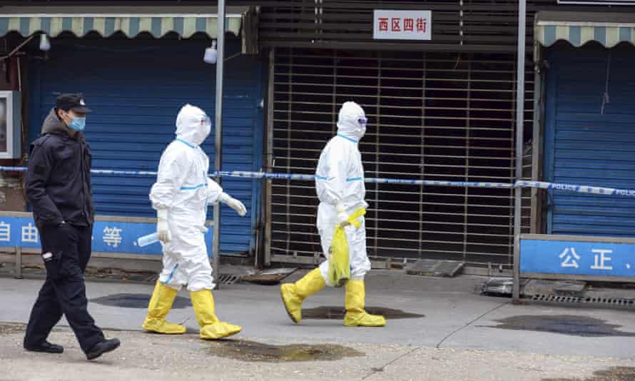 Workers in protective gear at the Huanan seafood market on 27 January 2020