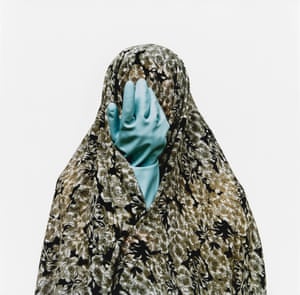 Woman in hijab with a blue rubber glove where her face should be