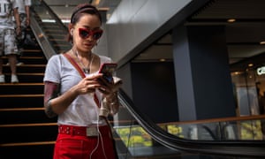 Woman on smartphone on escalator