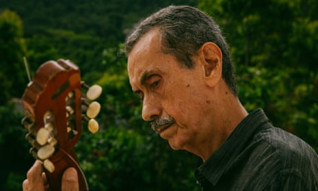 Arthur Verocai plays guitar outside at home in Rio de Janeiro.