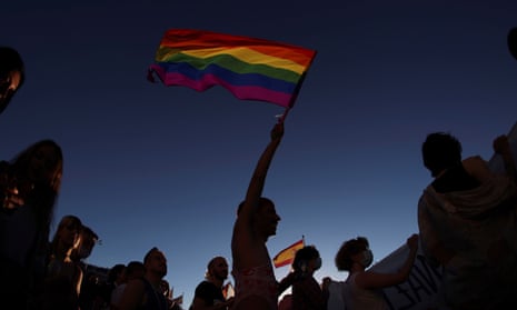 person waves rainbow flag