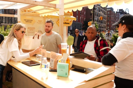 Staff with Misfits Market demonstrates the app to people at a pop-up in New York City.