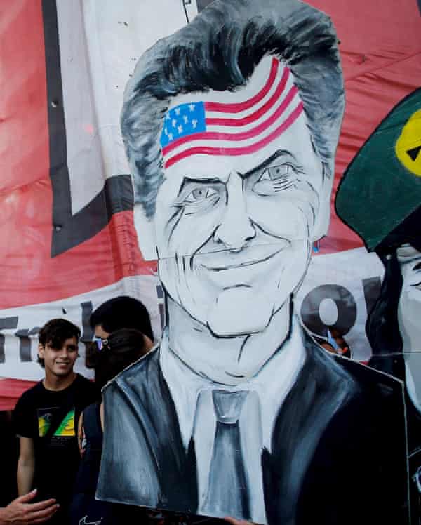 A man holds up an image depicting Argentina’s President Mauricio Macri, during a demonstration in Buenos Aires