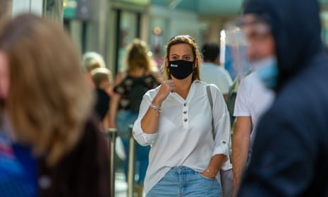 High street with a woman wearing a face mask