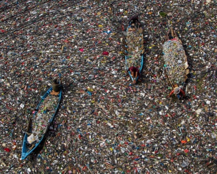 People on boats collect recyclable plastics from the heavily polluted Citarum River in Bandung, West Java, Indonesia.