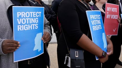 People hold signs reading "Protect Voting Rights" and "My Vote = My Voice" at a rally