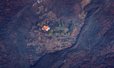 Lava flows surround a house following the eruption of a volcano in the Cumbre Vieja national park at El Paso, on the Canary Island of La Palma