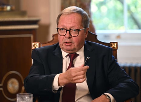 Andrey Kelin in a suit and tie, gesturing while holding a pen