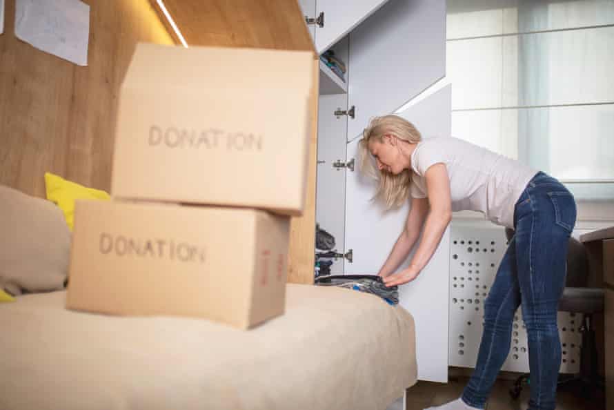 Woman sorting clothes from her sons closet for donation