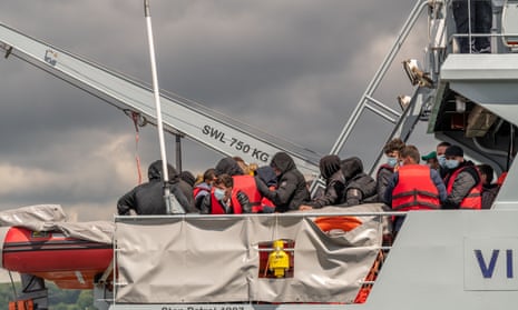 A group of refugees arriving into port on a coastguard vessel in Dover.