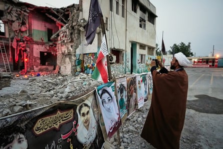 A man taking a photograph of memorials at the shattered Shajareh Tayyebeh school in Minab, hit by a US airstrike in February.