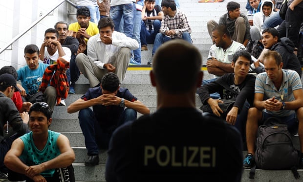 Refugees wait for registration after arriving Germany at the main station in Rosenheim on Tuesday.