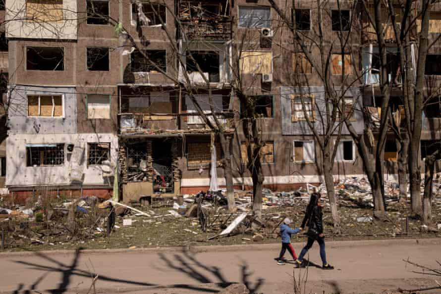 A woman and her child walk past a residential apartment block damaged in Kramatorsk, Ukraine.