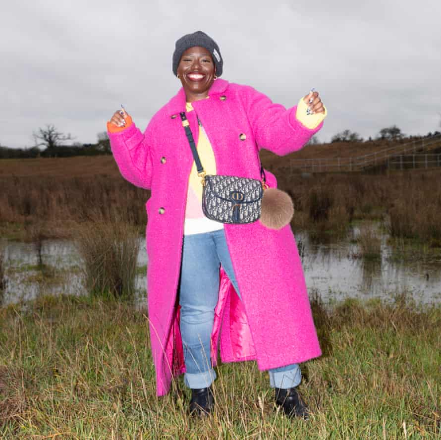 Candice Braithwaite wearing jeans, a jumper and a shocking-pink coat