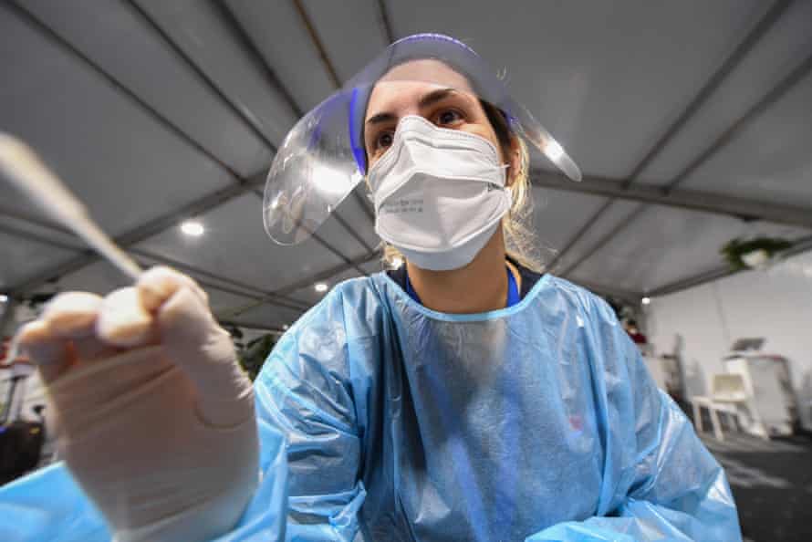 A nurse prepares a PCR test on a passenger at a pre-departure Covid clinic at Sydney airport