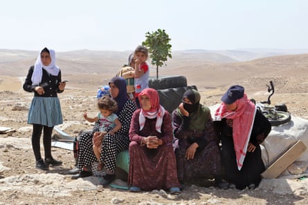 The family sit together in the sun-scorched region.