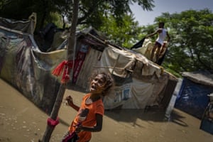 A young girl cries stands outside her shanty after floodwaters inundated homes along the banks of the Yamuna River in New Delhi, India