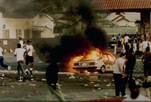 A car burns as looters take to the streets at the intersection of Florence and Normandie Avenues in 1992.