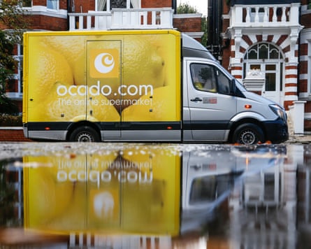 An employee of Ocado leaves his delivery truck parked as he makes a grocery delivery to a residential home in the St John’s Wood district of London, UK.