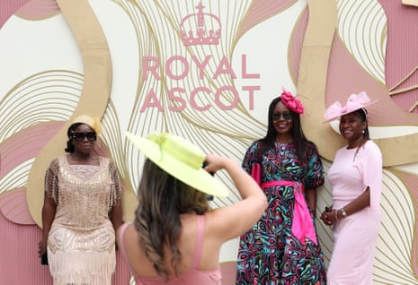 Racegoers pose for photos with the Royal Ascot logo ahead of the day's races.