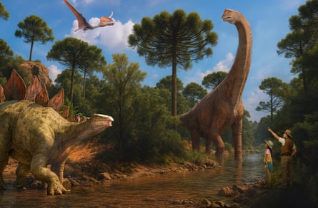 A pterosaur flies above two dinosaurs in a river watched by a man and a child in gameplay footage from the Age of Dinosaurs