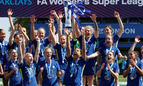 Chelsea striker Sam Kerr throws the WSL trophy into the air.