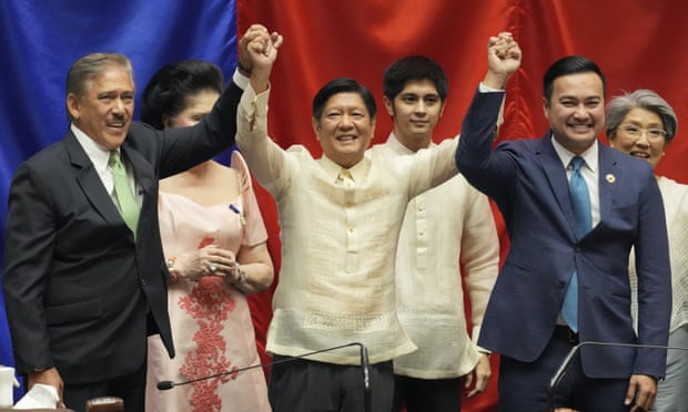 President-elect Ferdinand Marcos Jr., centre, raises hands with Senate President Vicente Sotto III, left, and House Speaker Lord Allan Velasco.