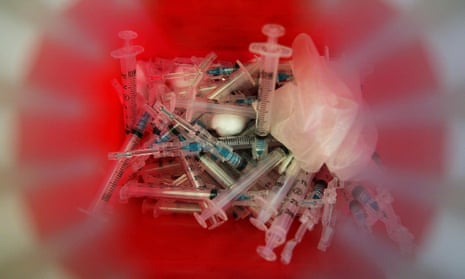 syringes in sharps disposal container