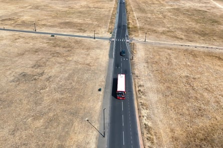 Aerial view of bus surrounded by parched grassland in London