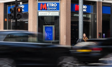Cars drive past a branch of Metro Bank