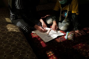 Sahar, 17, an 11th grade secondary school student, helps her sister, Hadia, 10, a 4th grade primary school student, with her homework.