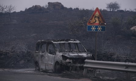 A car left destroyed by the blaze in the province of Oristano