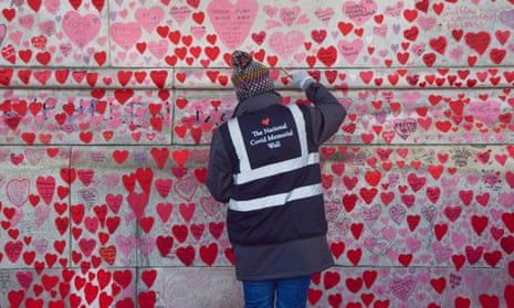 Volunteers repaint hearts on the national Covid memorial wall in London.