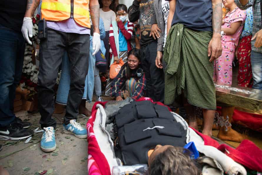 The body of Saw Pyae Naing. A relative is crying at his feet among a crowd of people