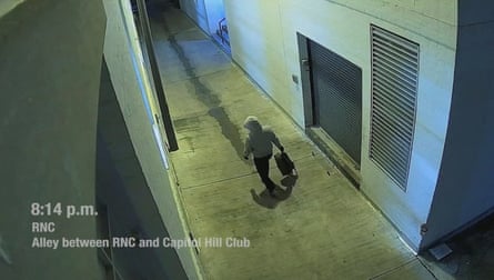 a person carrying a bag as they walk down hallway