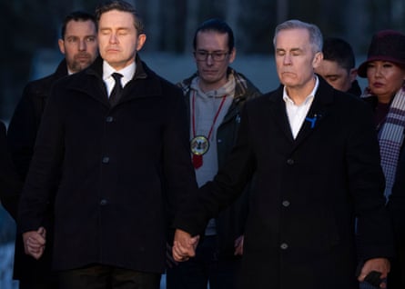 Prime minister Mark Carney and Conservative leader Pierre Poilievre join hands while attending the vigil