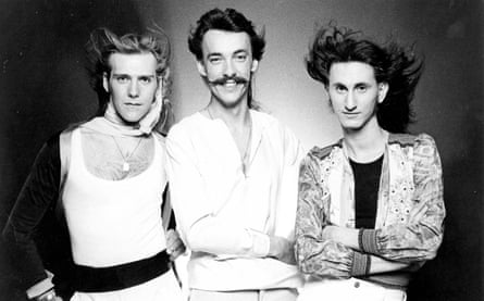 The band members with wind-blown hair and low-cut 1970s shirts