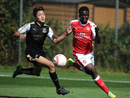 A young Bukayo Saka chases the ball alongside a Swindon Town academy player