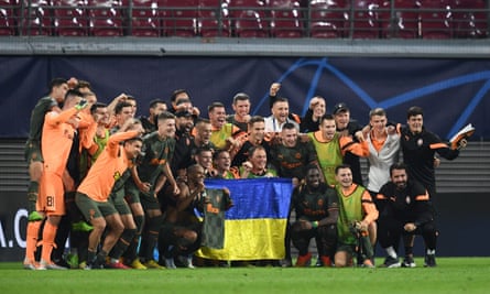 Shakhtar Donetsk players pose with the flag of Ukraine after their victory.