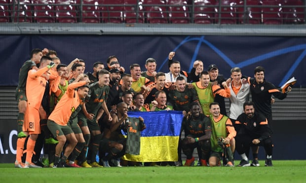 Shakhtar Donetsk players pose with the Ukrainian flag after their victory.