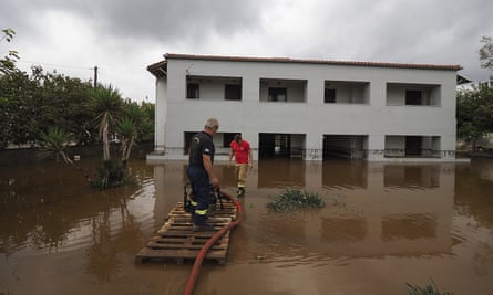 Firefighters pump water following a flood at the village of Agia Anna, at the northern part of Evia.