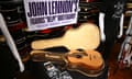 A guitar in a case beside photos and under a large sign reading 'John Lennon's Framus "Help!" Hootenanny