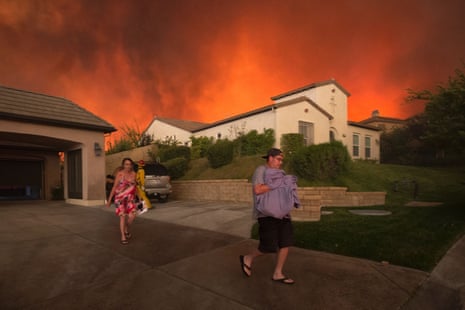 Residents flee their home as flames from the Sand Fire on 23 July 2016 near Santa Clarita, California. 