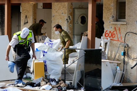 A search team works outside a destroyed house in Kfar Aza kibbutz, which was targeted in the 7 October Hamas attack
