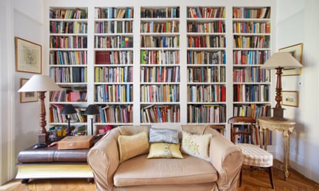 A living room with a packed bookcase.