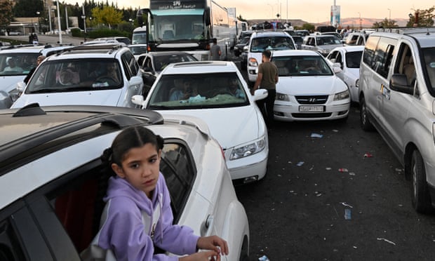 People fleeing from Lebanon arrive on the Syrian side of the border.