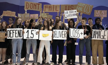Youth activists at Cop27 in Egypt hold signs encouraging leaders to limit warming to 1.5 degrees.